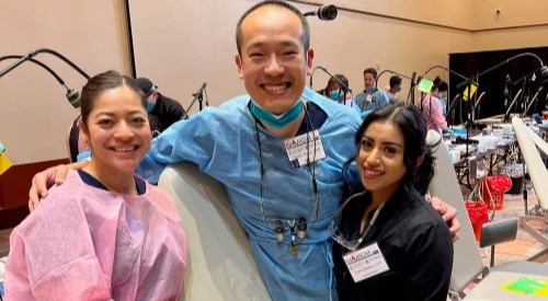 Doctor Zhang and two dental team members smiling at volunteer dental clinic