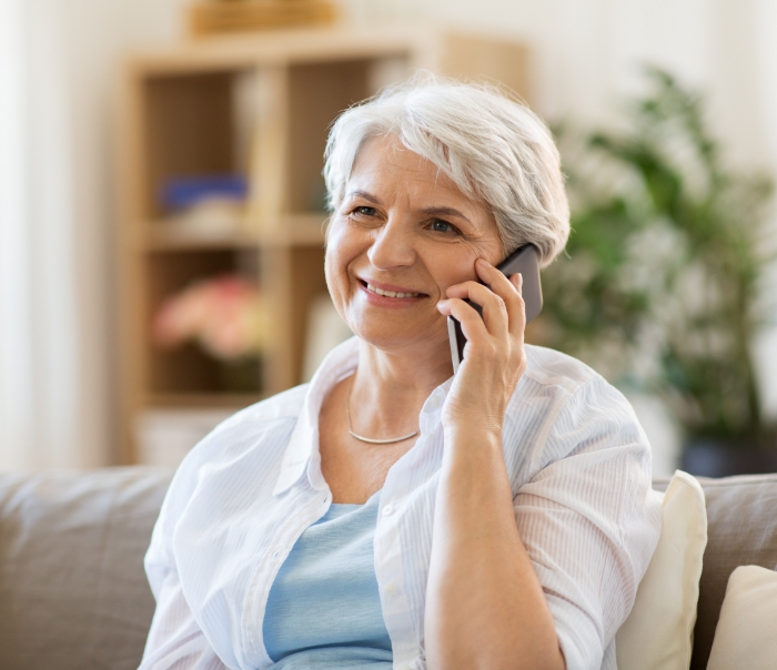 Senior woman talking on phone with Santa Fe dental office