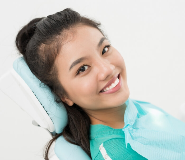 Woman in dental chair smiling after cosmetic dentistry in Santa Fe