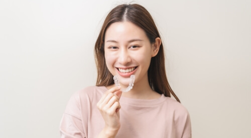 Smiling woman holding a teeth whitening tray