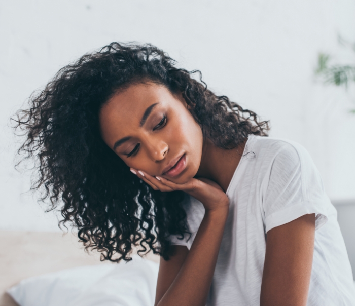 Woman holding her mouth in pain before emergency dentistry in Santa Fe