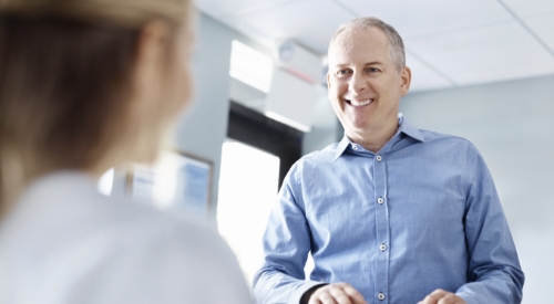 Man smiling at dental office receptionist