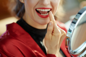 Close up of woman looking in mirror to examine her beautiful smile