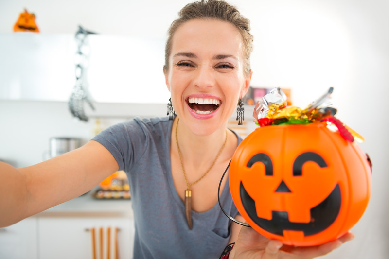 Patient smiling with a Halloween bucket after good dental care