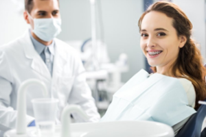 Patient smiling as her dentist prepares to start her checkup and cleaning